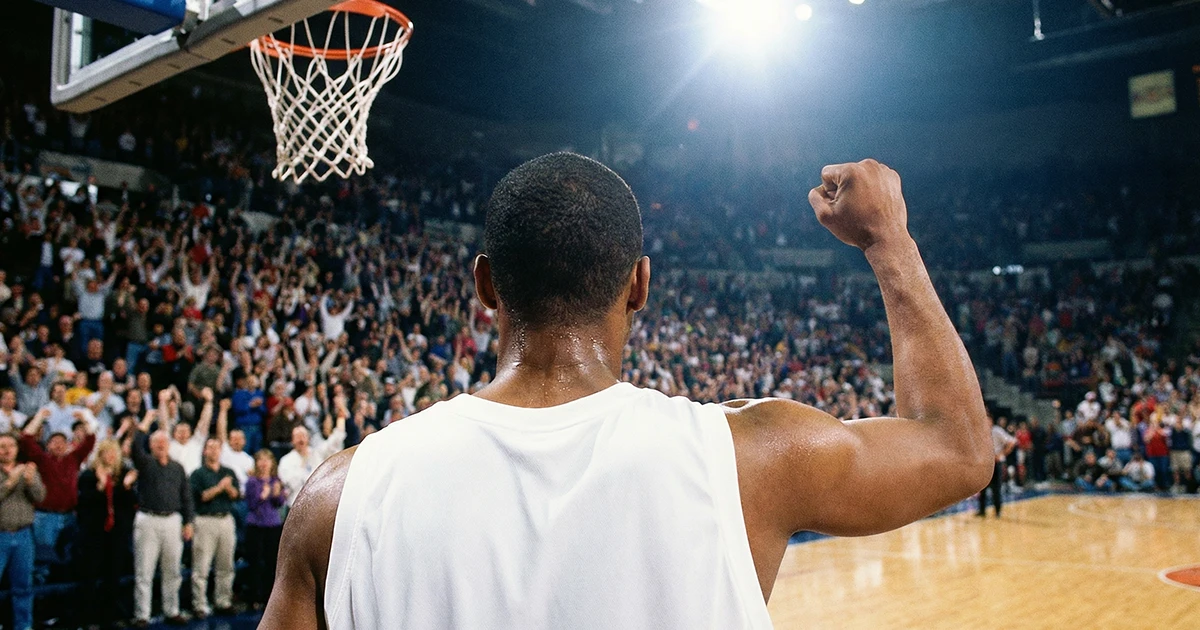 Jugador de baloncesto celebrando con el puño en alto tras anotar una canasta decisiva